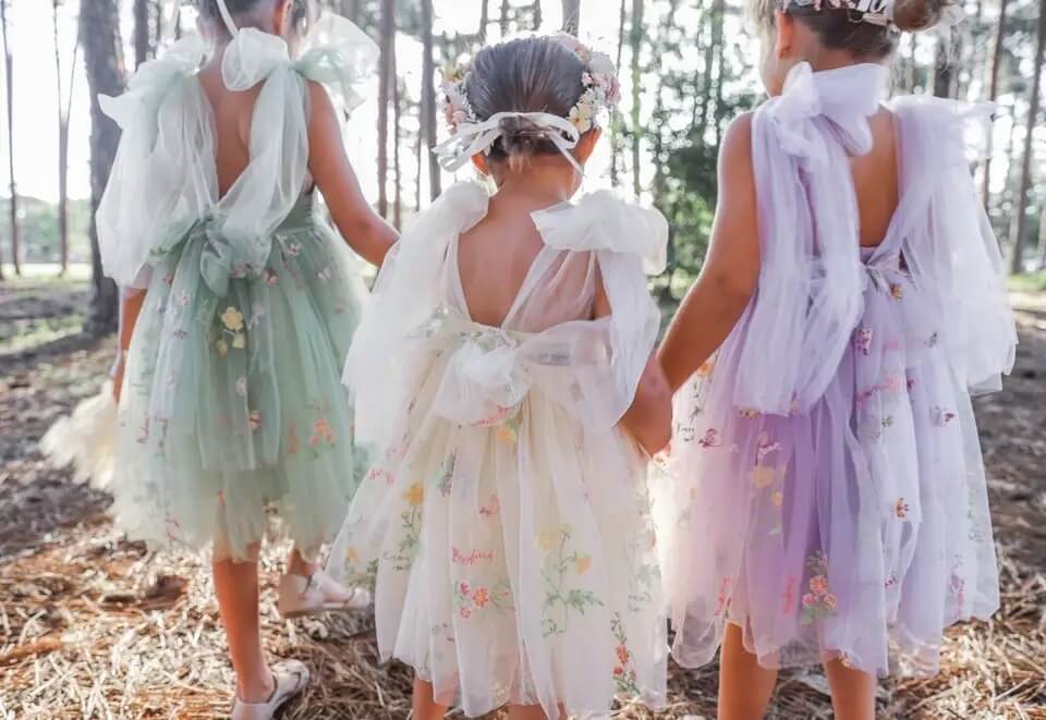 3 young girls wearing pretty dresses