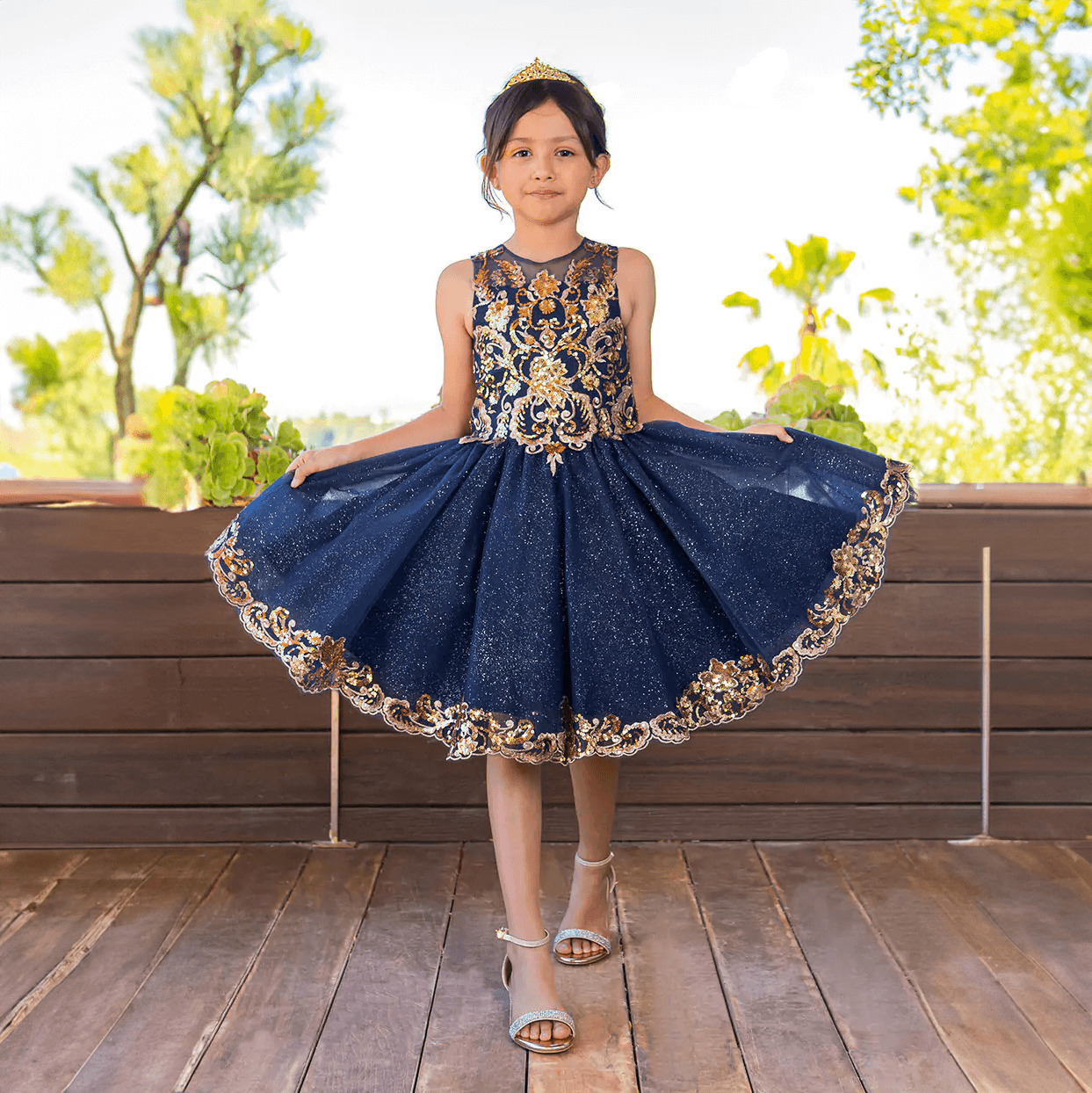Girl in a crown wearing a beautiful navy and gold sequin dress